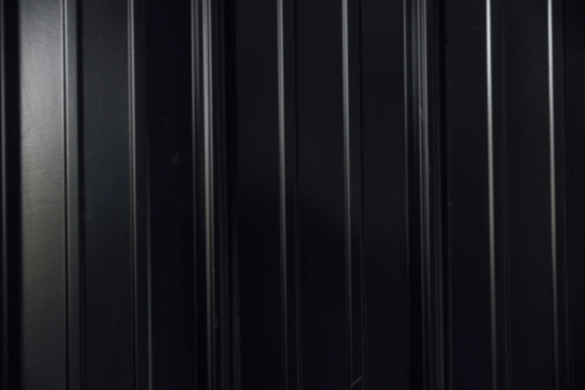 Dark corrugated metal roofing panels, blurred as background